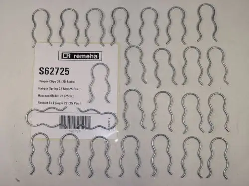 Haarnadelfedern in metallischer Ausführung, angeordnet auf einer Verpackung mit dem Logo der Marke Remeha. Enthalten sind mehrere Clips in einer geordneten Anordnung.